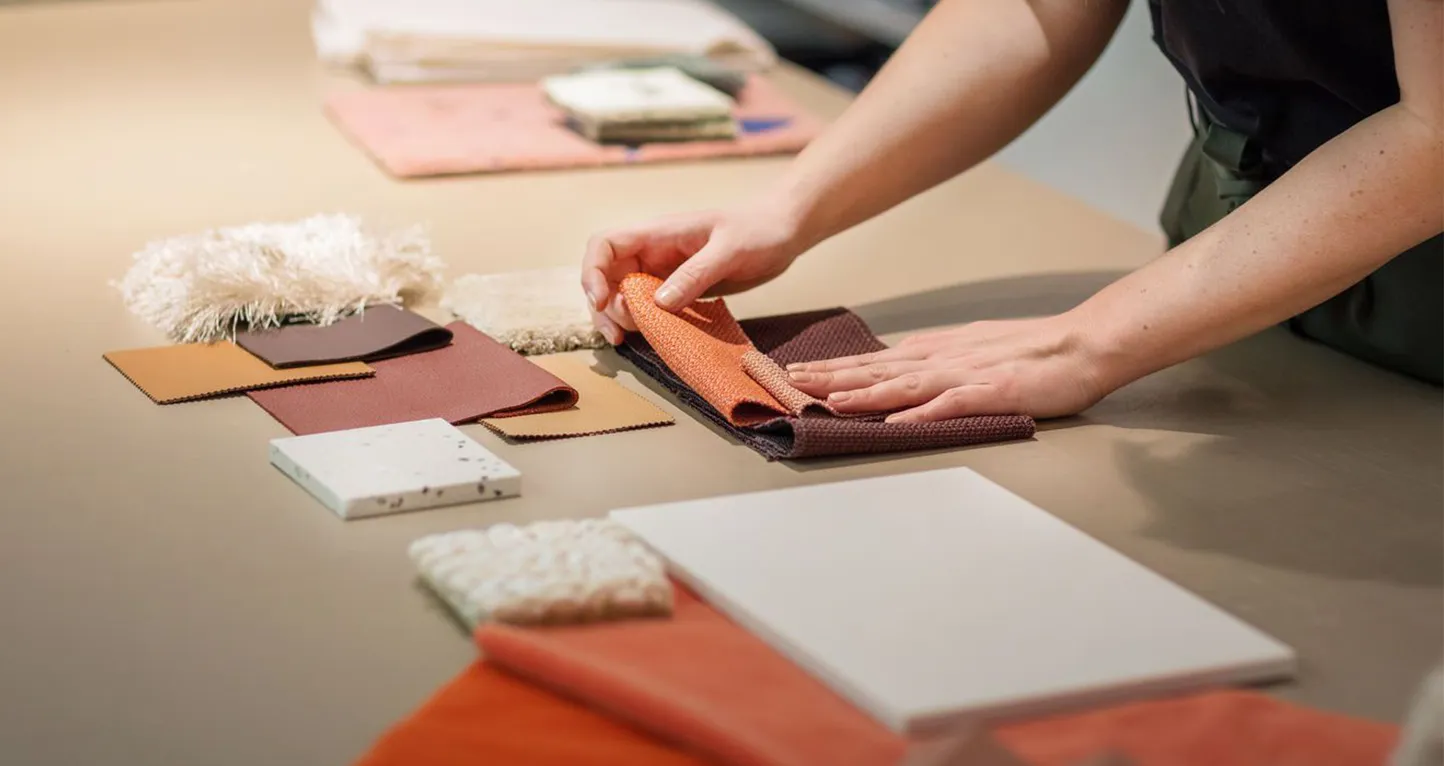 Person arranging fabric samples on a table